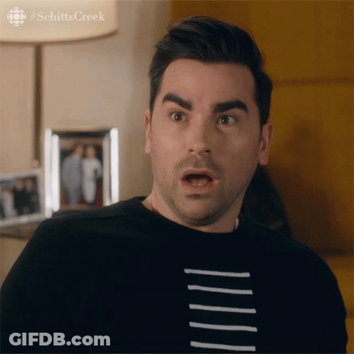 A Man With A Surprised Look On His Face Is Wearing A Black Shirt With White Stripes GIF
