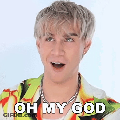 A Man With A Surprised Look On His Face Is Wearing A Colorful Shirt And A Chain Necklace . GIF