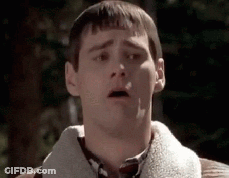 A Man With A Surprised Look On His Face Is Wearing A Sweater And A Plaid Shirt . GIF