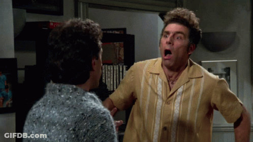 A Man With A Surprised Look On His Face Looks At Another Man GIF