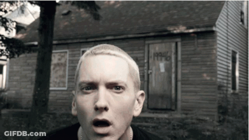 A Man With A Surprised Look On His Face Stands In Front Of A House That Says 1990 On The Door GIF