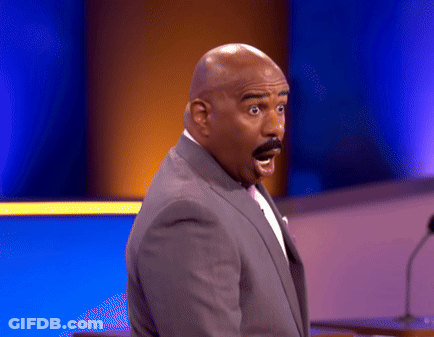 A Man With A Surprised Look On His Face Stands In Front Of A Microphone GIF