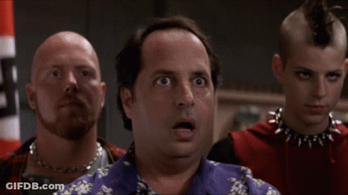 A Man With A Surprised Look On His Face Stands In Front Of Two Other Men GIF