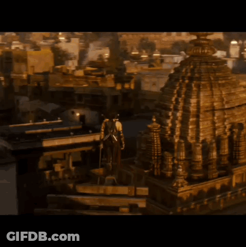 A Man With A Sword On His Back Stands In Front Of A Building GIF