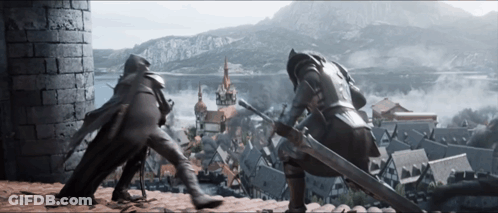 A Man With A Sword Standing Next To Another Man GIF