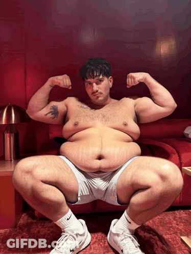 A Man With A Tattoo Of A Palm Tree On His Arm Squatting Down GIF