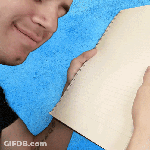 A Man With A Tattoo On His Arm Holds A Notebook GIF