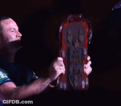 A Man With A Tattoo On His Arm Holds Up A Plaque That Says World State Of Origin GIF