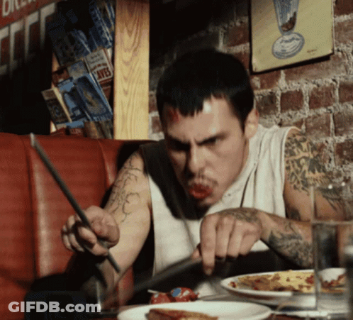 A Man With A Tattoo On His Arm Is Eating A Pizza GIF