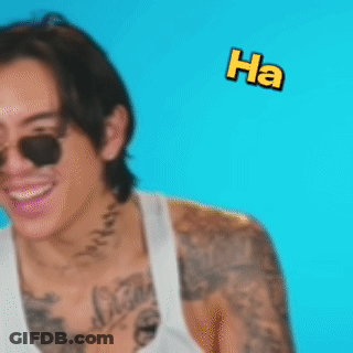 A Man With A Tattoo On His Arm Is Laughing With The Words Ha Flying Around Him GIF