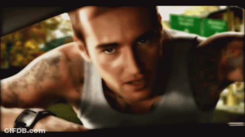 A Man With A Tattoo On His Arm Is Looking At The Camera GIF
