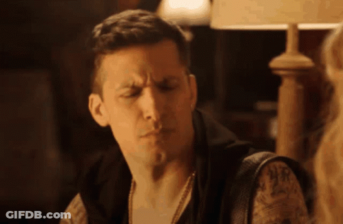 Man With Tattoo Sitting Under Lamp GIF