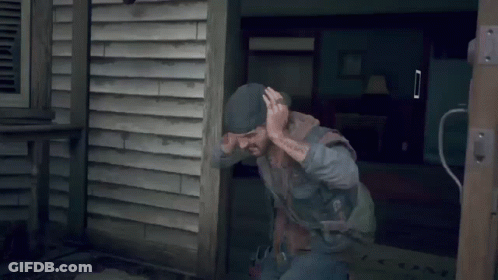 A Man With A Tattoo On His Arm Is Squatting On A Wooden Deck GIF