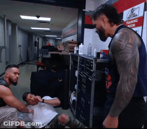 A Man With A Tattoo On His Arm Is Standing In Front Of A Sign That Says Training Room GIF