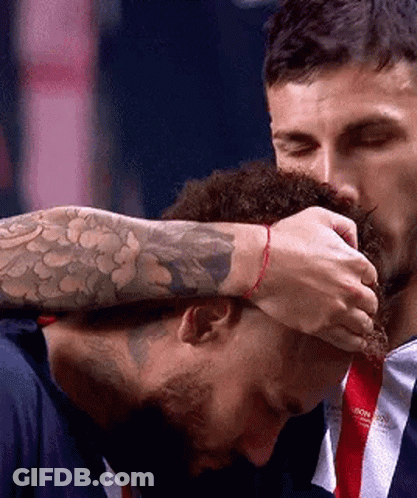 A Man With A Tattoo On His Arm Is Touching Another Man 'S Head . GIF