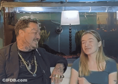 A Man With A Tattoo On His Arm Talks To A Girl GIF