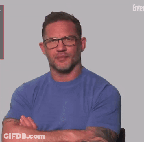 A Man With A Tattoo On His Arm Wearing A Blue Shirt And A Watch . GIF