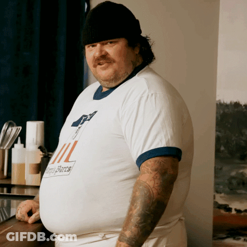 A Man With A Tattoo On His Arm Wears A Shirt That Says ' Ii ' On The Front GIF