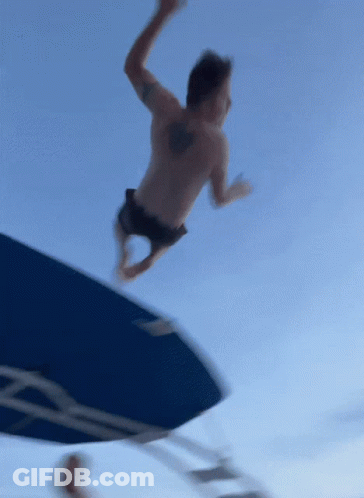 A Man With A Tattoo On His Back Is Jumping Into The Water GIF