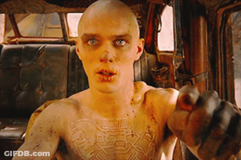 A Man With A Tattoo On His Chest Is Pointing GIF