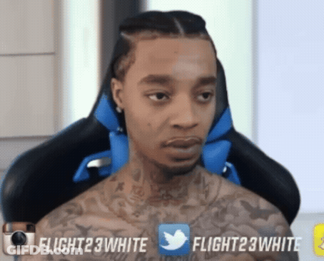 A Man With A Tattoo On His Chest Is Sitting In A Chair With Flight23white Written On The Bottom Right GIF