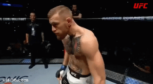 A Man With A Tattoo On His Chest Stands In A Boxing Ring With Ufc Written On The Bottom GIF