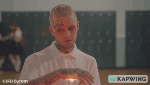 A Man With A Tattoo On His Forehead Holds A Lighter In His Hand GIF