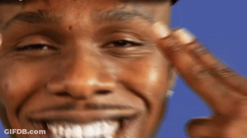 A Man With A Tattoo On His Forehead Is Smiling And Pointing At His Face GIF