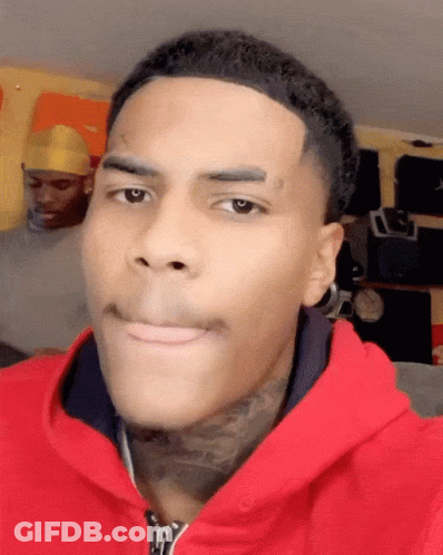 A Man With A Tattoo On His Forehead Wears A Red Jacket GIF
