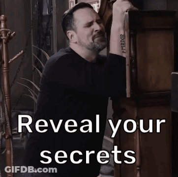 A Man With A Tattoo On His Wrist Is Standing Next To A Sign That Says Reveal Your Secrets GIF