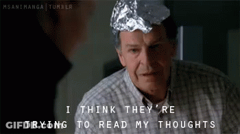 A Man With A Tin Foil Hat On His Head Says I Think They 'Re Trying To Read My Thoughts GIF