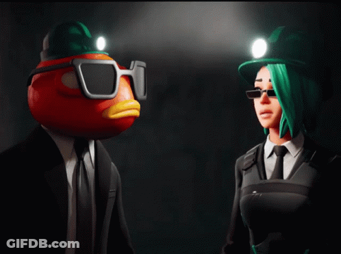 A Man With A Tomato Head And A Woman With Green Hair Standing Next To Each Other GIF
