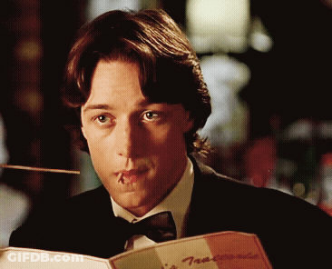 A Man With A Toothpick In His Mouth Is Reading A Menu At A Restaurant GIF