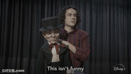 A Man With A Top Hat Is Standing Next To A Puppet That Says This Isn 'T Funny GIF