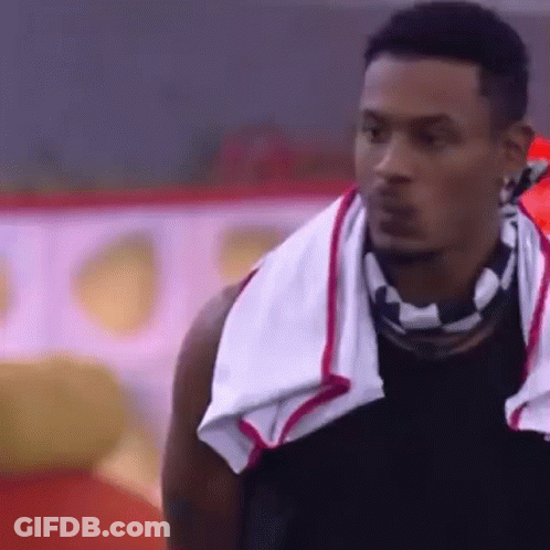 A Man With A Towel Around His Neck Is Looking At Something . GIF