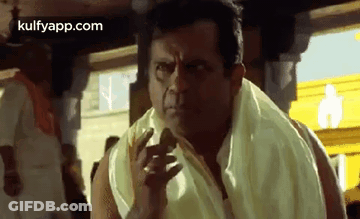 A Man With A Towel Around His Neck Is Making A Funny Face While Standing In Front Of A Crowd . GIF