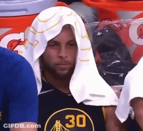 A Man With A Towel Wrapped Around His Head Is Wearing A Golden State Warriors Shirt . GIF