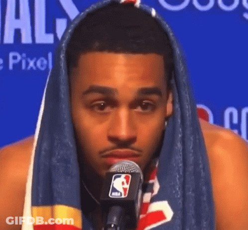 A Man With A Towel Wrapped Around His Head Talking Into A Microphone . GIF