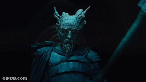 A Man With A Tree Face And A Beard Is Holding A Large Axe GIF