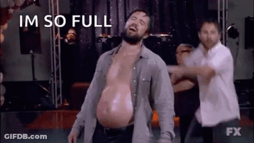 A Man With A Very Large Belly Is Dancing On A Stage With Other People . GIF