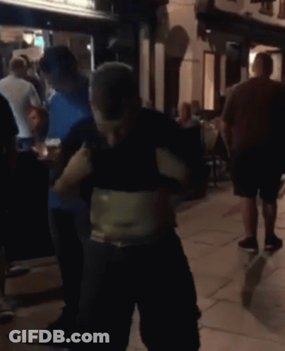 A Man With A Very Large Belly Is Standing In A Crowd GIF