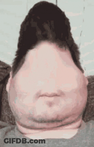 A Man With A Very Large Head And Neck Is Sitting On A Couch And Making A Funny Face . GIF