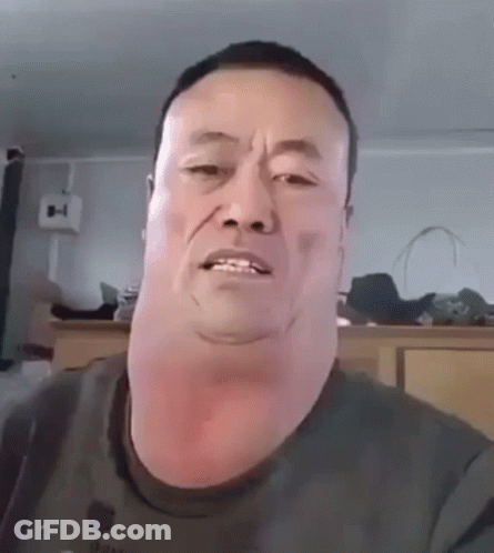 A Man With A Very Large Neck Is Making A Funny Face While Looking At The Camera . GIF