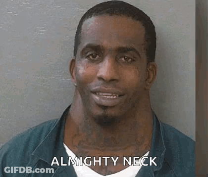 A Man With A Very Large Neck Is Smiling In A Mug Shot . GIF