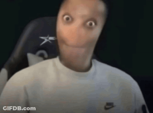 A Man With A Very Long Face Is Sitting In A Chair And Making A Surprised Face . GIF