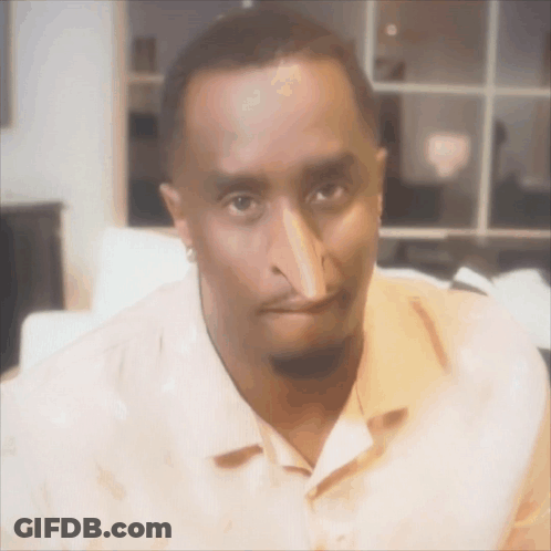 A Man With A Very Long Nose Is Wearing An Orange Shirt GIF