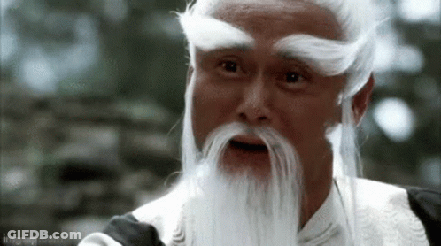 A Man With A White Beard And Mustache Is Looking At The Camera . GIF