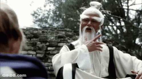A Man With A White Beard Is Talking To Another Man . GIF
