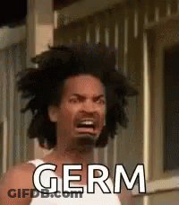 A Man With A White Tank Top Is Making A Funny Face And Saying Germ . GIF