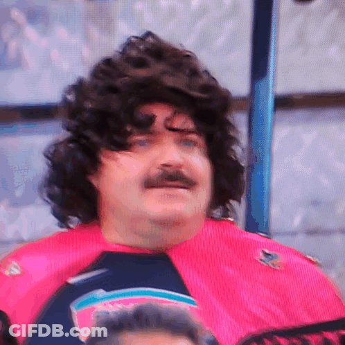 A Man With A Wig And Mustache Is Wearing A Pink Shirt That Says Sharks GIF